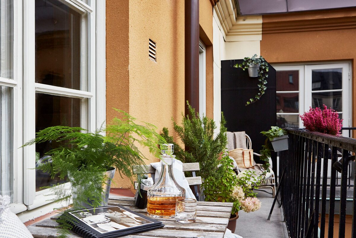 Начнем с балкона. Для декора использованы садовая мебель и растения в металлических кашпо