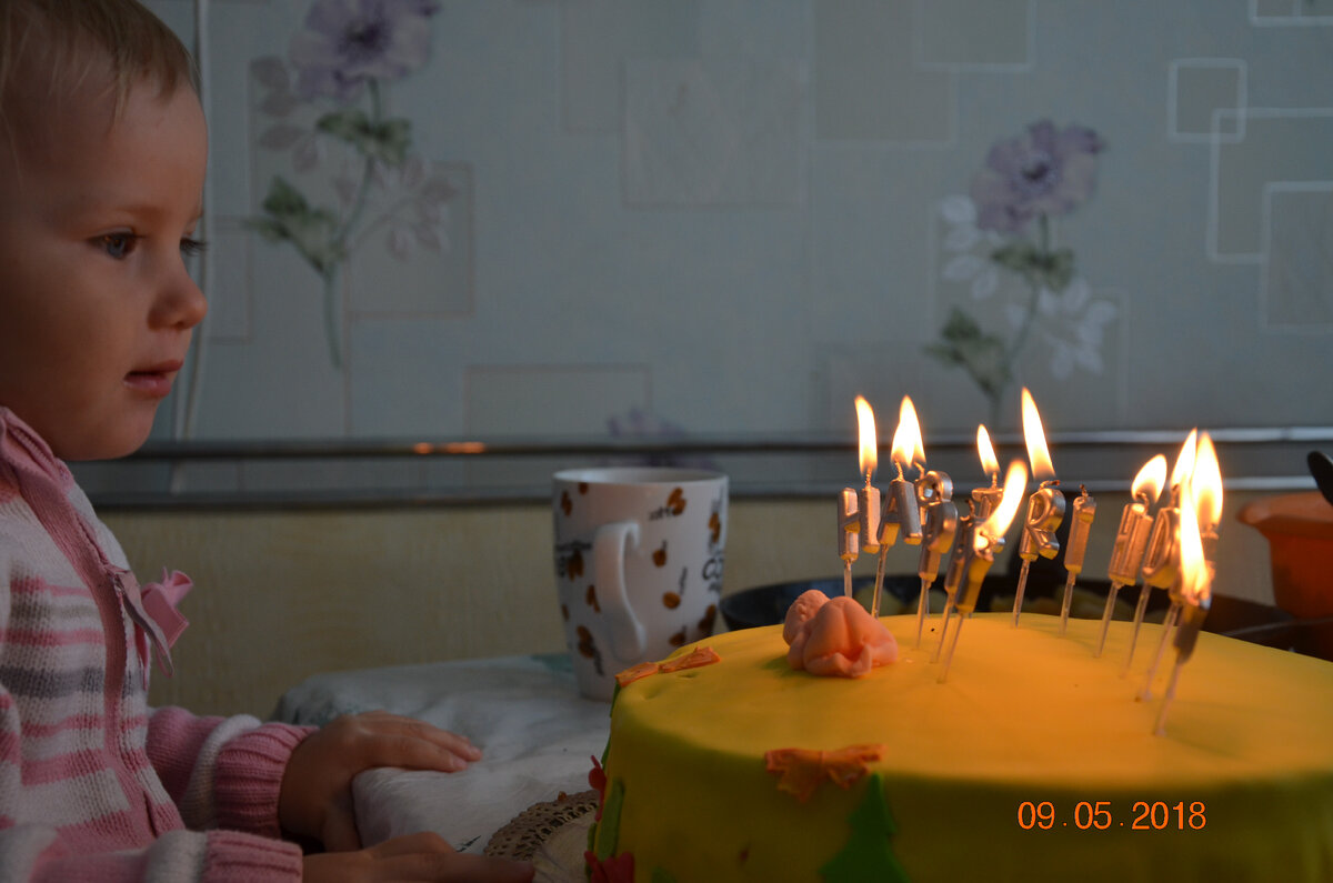 Порывшись, нашла фото, где дочке отмечаем 2 годика. Наглядно видно, что здесь я не успела оформить торт. Сделала вырубками фигурки из мастики и приклеила 