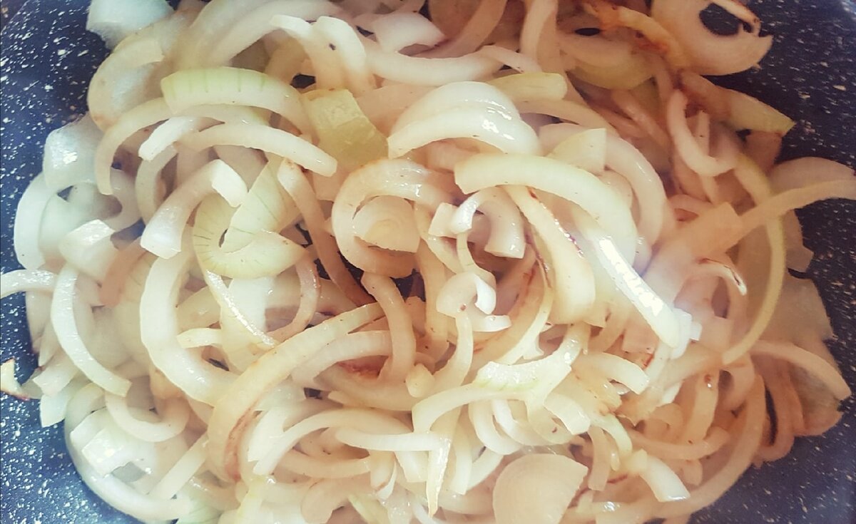 Лук обжариваем на отдельной сковороде, затем добавляем к курице