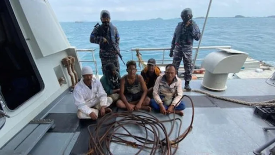 задержаные жулики в Индонезии. На переднем плане образец того, что они украли. Фото из сети.