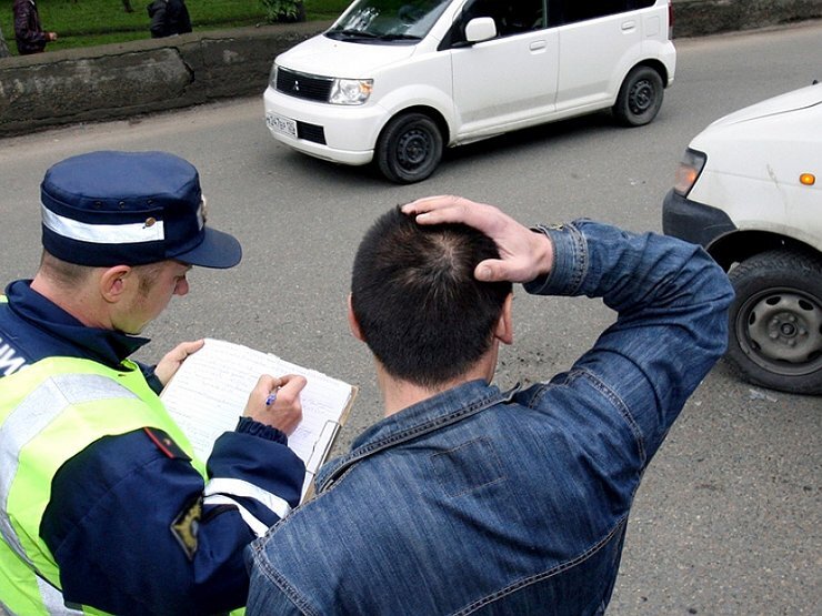 Полицейский опрашивает свидетелей аварии.