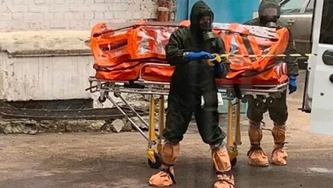 На этом фото наглядно  как двое мужчин  перевозят в изоляторе  человека  .