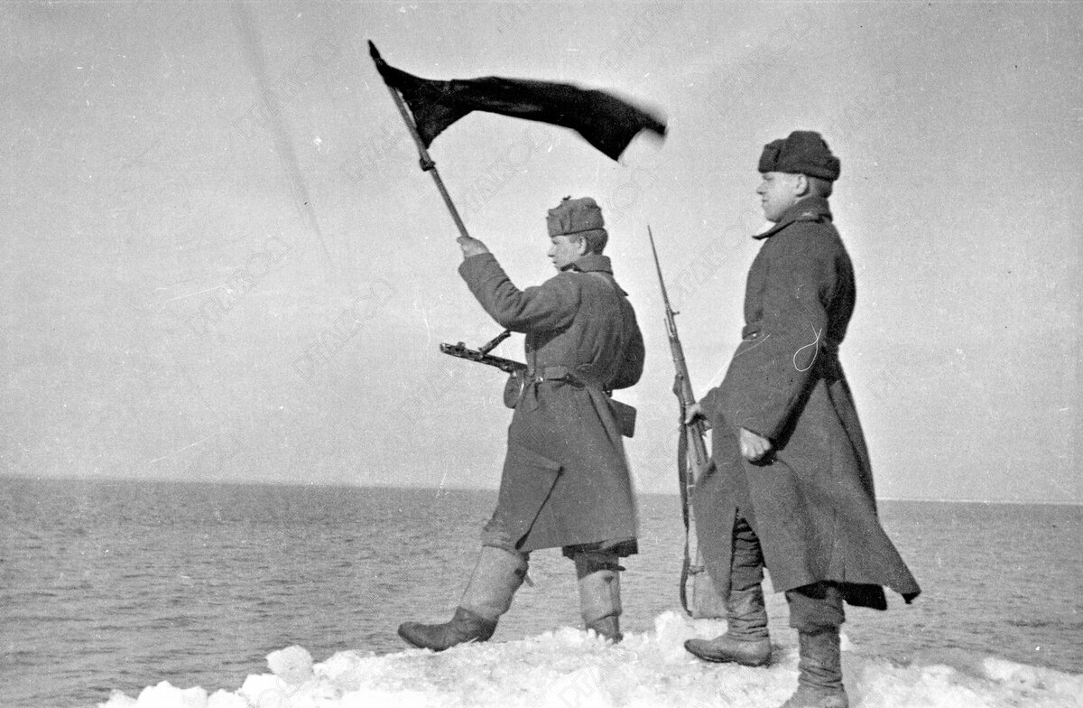 Советские бойцы с Красным флагом на берегу Балтийского моря.  Восточная Пруссия. Март 1945. Фотограф А.И. Становов. РГАКФД. Арх. №  0-331326