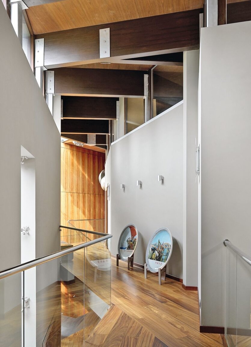 Задача была — сохранить конструктивистский стиль постройки в интерьере, но сделать его тёплым, комфортным и роскошным. Стремясь придать холодным минималистичным объёмам теплоту и уют, архитектор сделала ставку в отделке на натуральное дерево. «Интерьер буквально складывался, как мозаика, основой и фоном для которой стали поверхности и архитектурные элементы из дерева от «София-Декор».