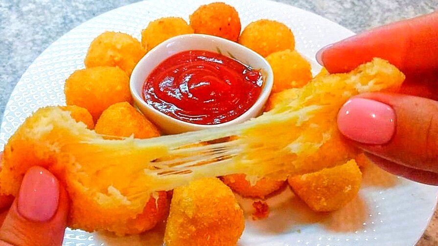 Сегодня мы с Вами приготовим целую гору потрясающе вкусных сырных шариков буквально за 10 минут. Хрустящая корочка снаружи, мягкие внутри, сыр тянется – вкуснота из сыра неимоверная. Я покажу очень короткий рецепт, а в конце расскажу главные секреты как приготовить идеальные сырные шарики, от которых голова будет кругом от наслаждения! 