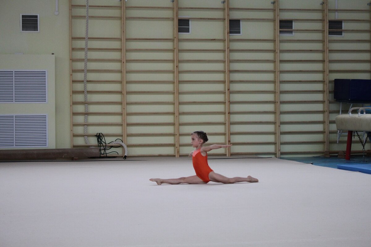 Моя дочь. Первые соревнования через три месяца посещения спортивной школы. Совсем не идеальный шпагат. Растяжка у дочки и сейчас, спустя два года, далека от идеала.