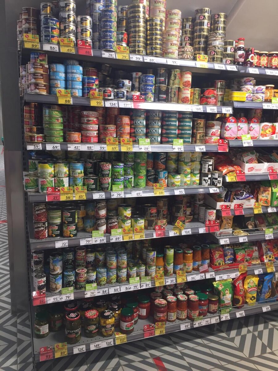 Фото полки с консервами. Очень много акционных предложений.