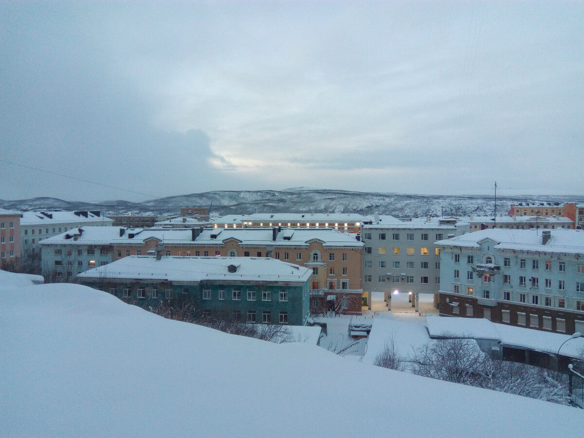 Мурманск. Над крышами домов виден высокий противоположный берег реки Колы.