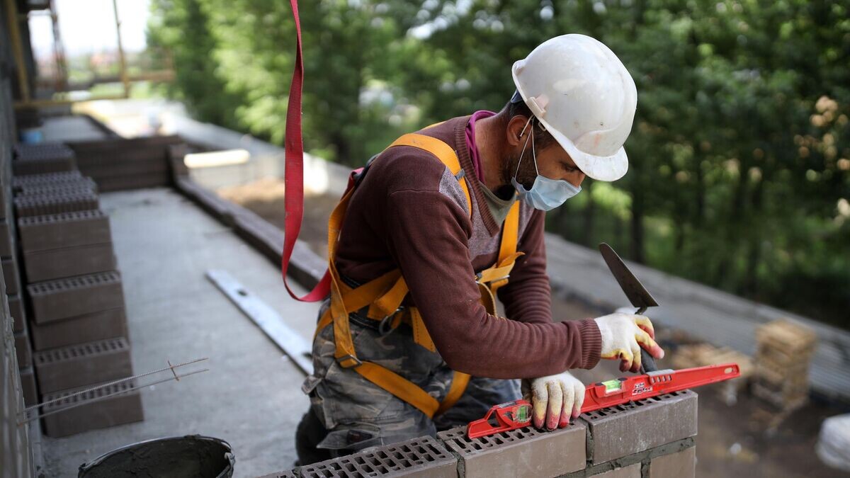    Рабочий на строительстве ЖК "Красная площадь" в Краснодаре© РИА Новости / Виталий Тимкив