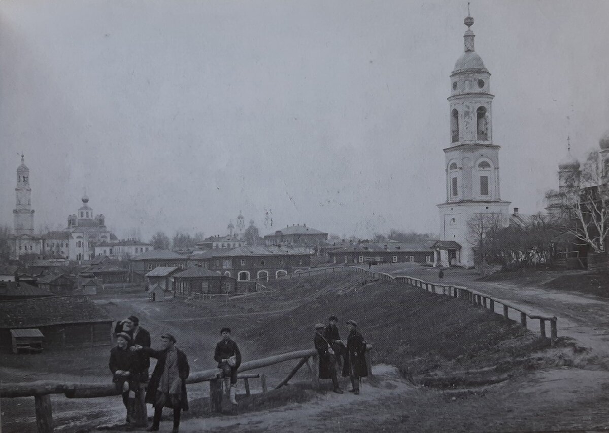 Вид на Базарную площадь города Темникова. 1932 г. Данная площадь была образована в треугольном уширении оврага «Самбег» в начале XVIII века. Неглубокая чаша рельефа подходила для размещения торговых построек. Рядом в каменных зданиях располагались склады товаров.  