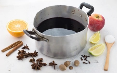 1. В кастрюлю налейте вино. Апельсин разрежьте пополам, лимон и яблоки на 4 части.