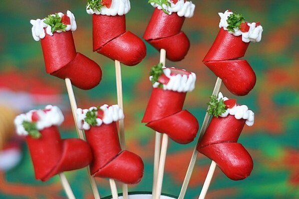 Колбаски для барбекю, крем-чиз или любой другой сливочный сыр, петрушка и кусочки красного болгарского перца для украшения. Из одной колбаски получается 2 носочка.