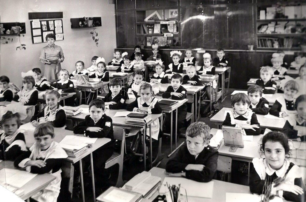 Школьники в форме начала 1980-х годов за столами, которые можно назвать антишелевром советского производства. Фото взято с ресурса Яндекс.Картинки 