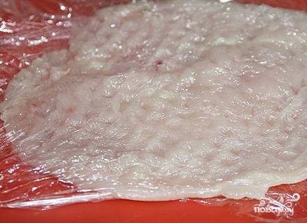 Куриное филе разрезать вдоль, завернуть в пленку и отбить с двух сторон.