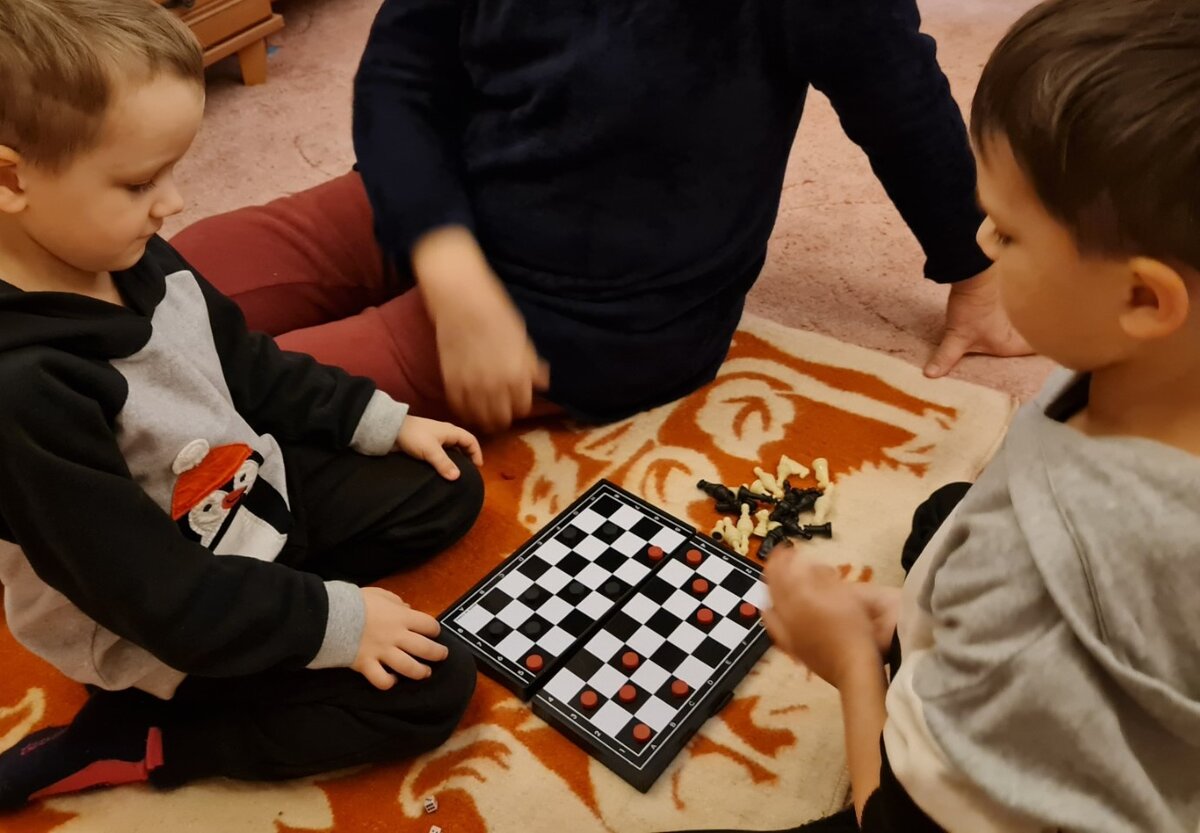 Игра с внуками в шашки. Фото: Женщина после 50