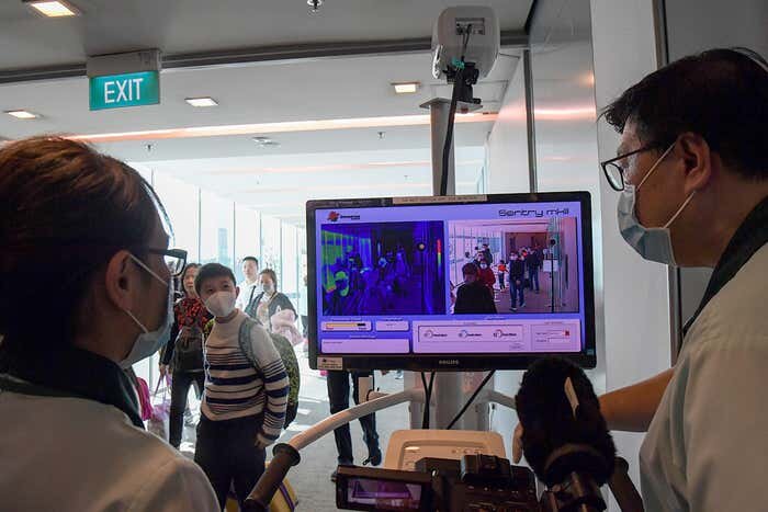 Чиновники здравоохранения Сингапура сканируют путешественников в попытке сдержать распространение нового вируса