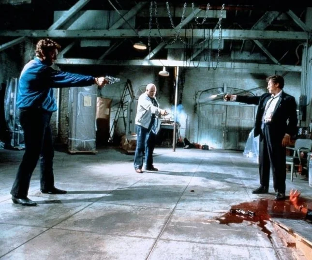 Мексиканская дуэль — любимый прием Тарантино. Кадр из Бешеных псов. Изображение с канала Ксении Бажен https://zen.yandex.ru/media/bazhen_kino/razbor-kultovogo-filma-tarantino-5cea41727b478b00b277c461