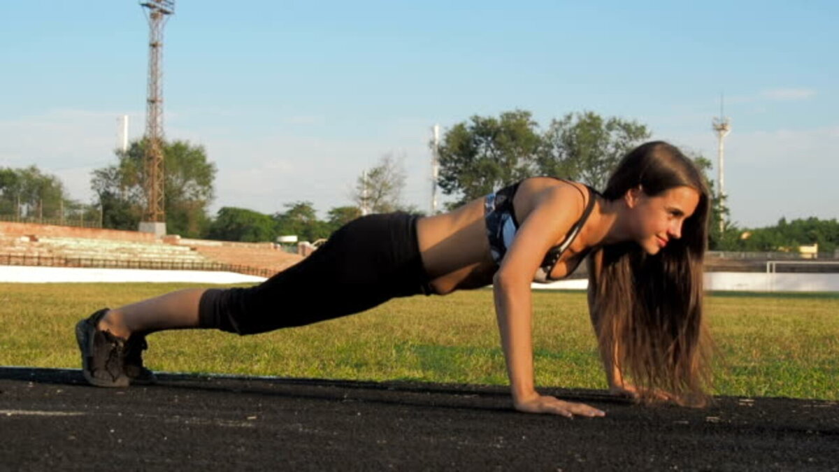 Девушка делает отжимания на стадионе. Фото автора: DMITRII GABIBOV