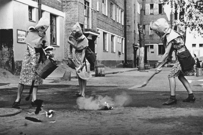 Москвички Нина Деева, Марина Никольская и Лиза Быстрова с защитными капюшонами на занятиях по тушению зажигательных бомб