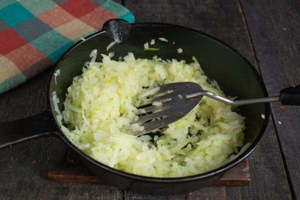 Нарезаем мелко репчатый лук. Лук можно использовать любой — порей, шалот или красный сладкий, вкус будет отличаться незначительно. Наливаем в скороду оливковое масло, кладём нарезанный лук, посыпаем соль, добавляем столовую ложку сливочного масла. Томим лук на умеренном огне 10-12 минут, перемешиваем.