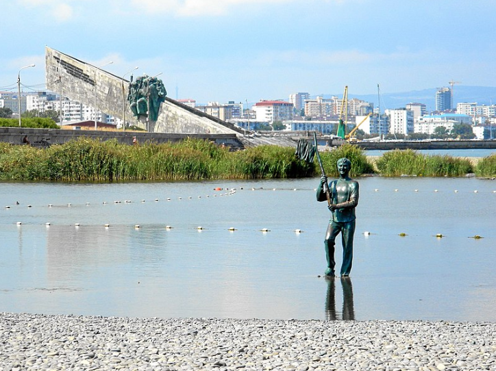 Геннадий Козодоев в городе Новороссийске выходит из моря наблюдая за мальчиком