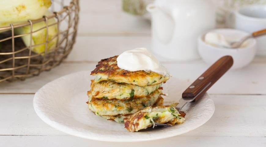 ИНГРЕДИЕНТЫ 2 небольших кабачка
1 небольшая луковица
3 зубчика чеснока
средний пучок укропа
2 яйца
2/3 стакана муки
1/2 ч. л. разрыхлителя
растительное или топленое масло для обжаривания
соль, свежемолотый черный перец
ПОШАГОВЫЙ РЕЦЕПТ ПРИГОТОВЛЕНИЯ
Шаг 1
Кабачки очистите от кожуры (если кабачки совсем молодые, можно кожуру оставить) и натрите на крупной терке. Положите в сито и отожмите сок.
Шаг 2
Лук и чеснок очистите и измельчите. Укроп мелко нарежьте.
Шаг 3
Смешайте кабачки с луком и зеленью. Добавьте яйца, муку, разрыхлитель и перец. Тщательно перемешайте. Не солите, иначе кабачки мгновенно дадут сок. Солить лучше каждый оладушек сверху, когда они уже на сковородке – старайтесь делать это аккуратно и равномерно.
Шаг 4
Хорошо разогрейте сковороду, налейте немного растительного масла. Вливайте столовой ложкой кабачковую смесь и обжаривайте под крышкой по 1,5 мин. с каждой стороны. Подавайте со сметаной.