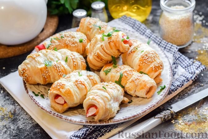 тесто слоеное, крабовые палочки, сыр твёрдый, яйца, масло растительное, кунжут, зелень, соль, перец чёрный молотый