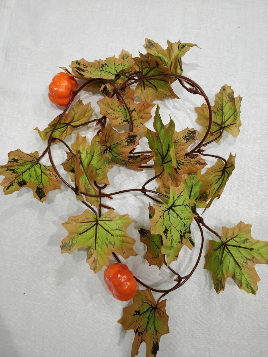 Гирлянда представляет из себя металлическую нить в пластмассовом корпусе,на которой крепятся листья из ткани. 