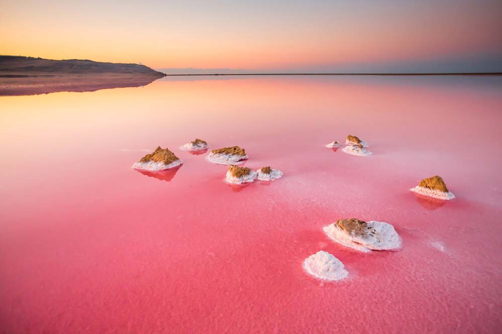 ЦВЕТНЫЕ ОЗЕРА... В Крыму немало соленых озер, многие из которых имеют лечебные свойства. На Западе это Ярылгач и Джарылгач под Межводным, Караджа у Оленевки, Ойбурское у Штормового, Мойнакское у Евпатории и самое знаменитое – Сакское. На Востоке – Качик, Тобечик, Узунларское, Чублашское и др. Среди них есть и цветные – всех оттенков розового и сиреневого, меняющихся в зависимости от освещения. Так что вам не обязательно ехать в Австралию, Америку или Африку, чтобы полюбоваться этой экзотикой. А это одно из самых необычных мест Крыма — озеро Сасык между Евпаторией и Саками, почти напротив аквапарка «Банановая республика«: Кстати, в России увидеть водоемы розового цвета можно и в других местах, например, Баскунчак в Астраханской области и Бурсоль на Алтае.