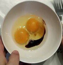 Лёгким движением руки разбиваем яйца в тарелку и добавляем соевый соус.