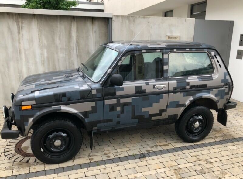 НИВА 2121 на фоне бетонного забора. 