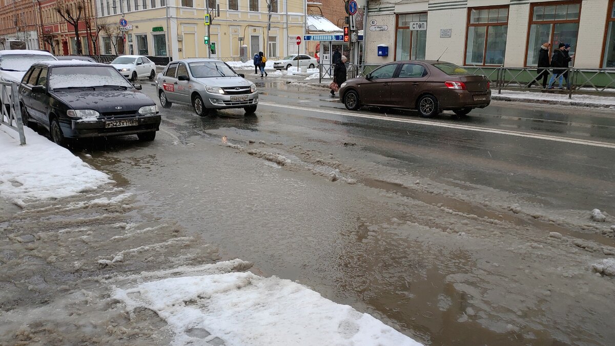Лужи из снега и воды вдоль дороги.