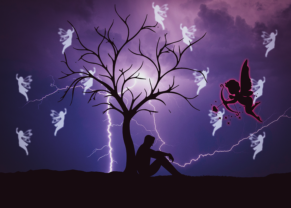 Мужчина сидит у дерева.