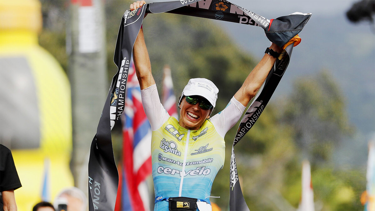 Энн Хауг с финишной лентой в руках празднует победу в чемпионате мира IRONMAN. Фото: DPA | Marco Garcia