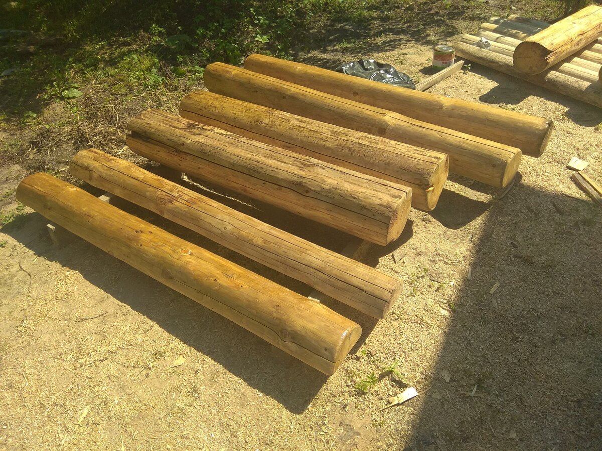 Бревна в процессе покрытия лаком