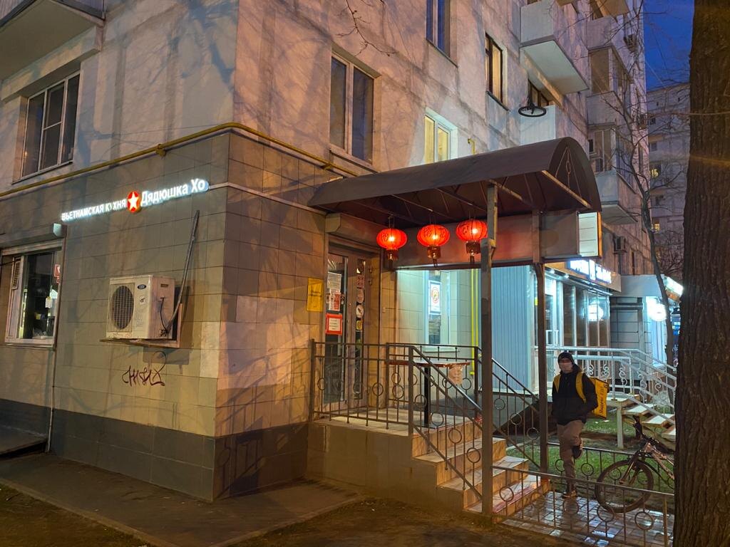 Одинокий курьер, ждёт заказ у соседнего заведения 