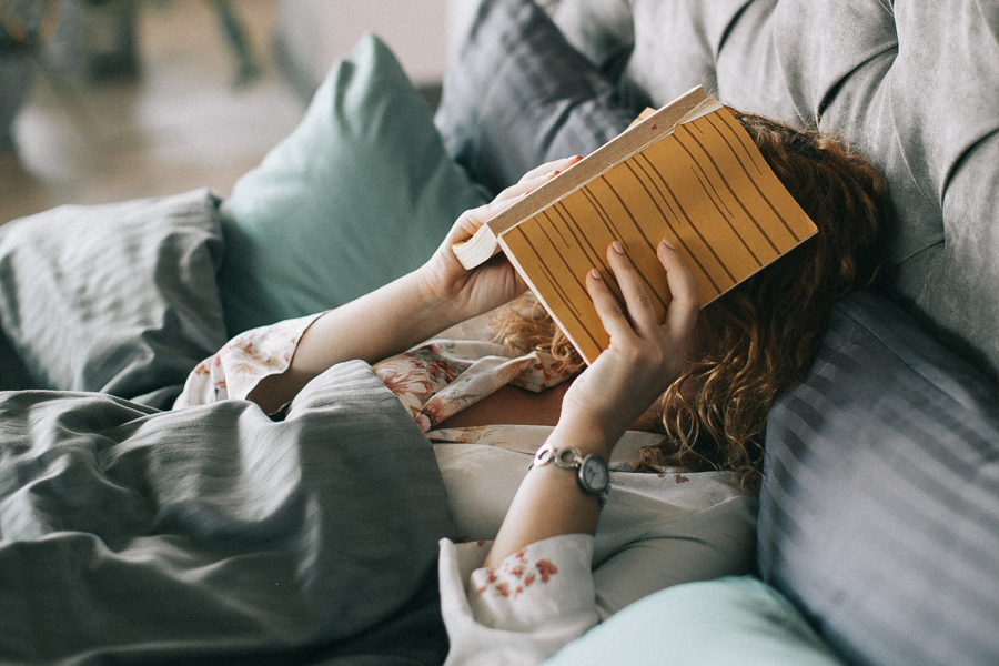 https://www.pexels.com/photo/woman-covering-face-with-book-on-bed-1524232/
