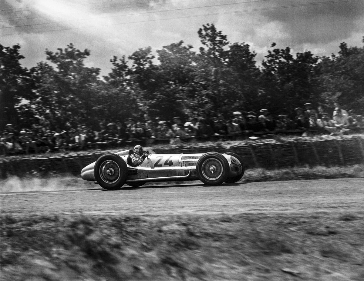 А что уж говорить про автомобили высшего класса Gran Prix с их мощнейшими двигателями. К примеру этот Mercedes-Benz Formula Rennwagen (W154) распологал 3-х литровым V12 с двухступенчатым компрессором типа Roots и выдавал.... 450-480 лошадей. В качестве топлива использовалась гремучая во всех смыслах смесь из метанола, нитробензина, ацетона и серы. Механики которые обслуживали машину реально работали в противогазе и резиновых перчатках. В снаряжённом состоянии весила машина примерно 980 кг. Как Жигулёнок. При этом она и её конкуренты вполне реально ехали за 300. Шлем? Зимнюю шапку носите? Вот примерно то-же самое. Только вместо вязки машинной или бабушки два слоя толстой кожи. И всё.