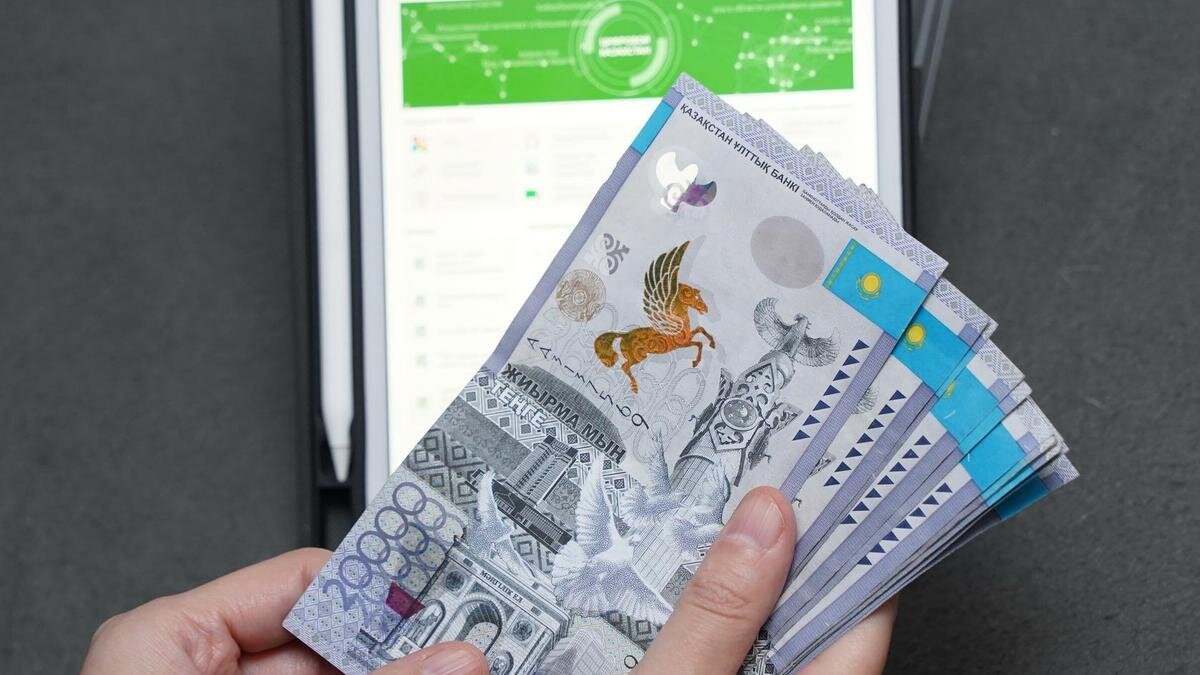    Женщина держит пачку денег на фоне планшета:NUR.KZ/Владимир Третьяков