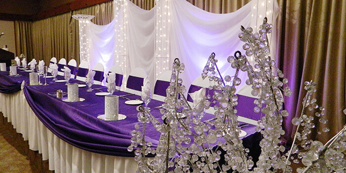 Белая фуршетная юбка, традиционная для столов на свадьбе, задает торжественный настрой и прекрасно оттеняет цветные скатерти 