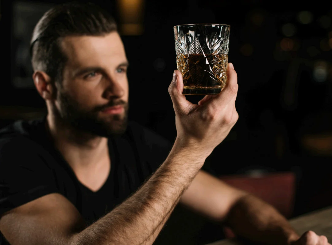 Мужчина постоянно пьет. Мужчина с бокалом виски. Парень со стаканом. Мужчина пьет виски. Мужик и стакан.