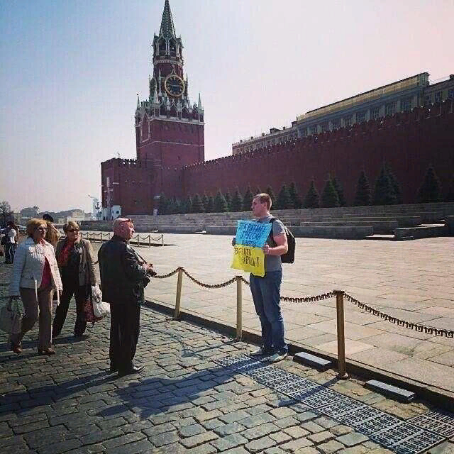 Украинский флаг на красной площади. Возле Кремля парень. Украинец на фоне Кремля.