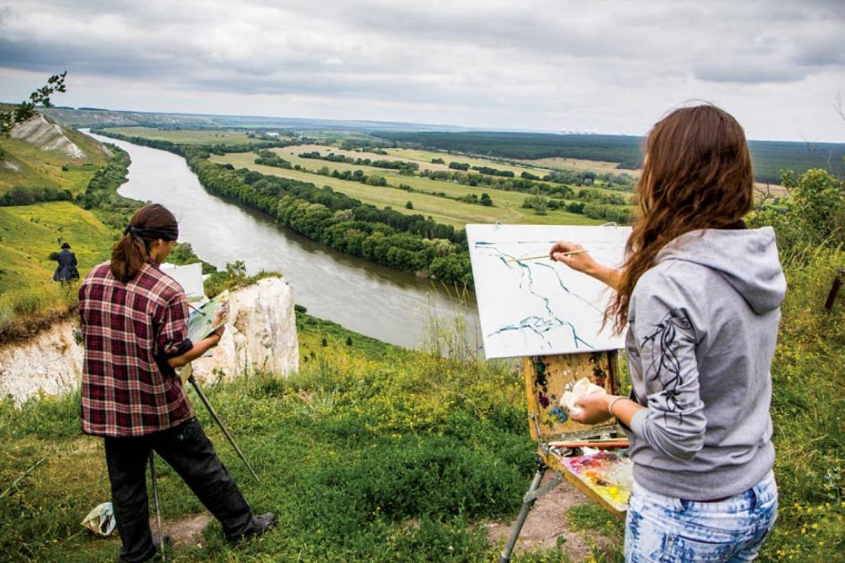 Девушка рисует на природе