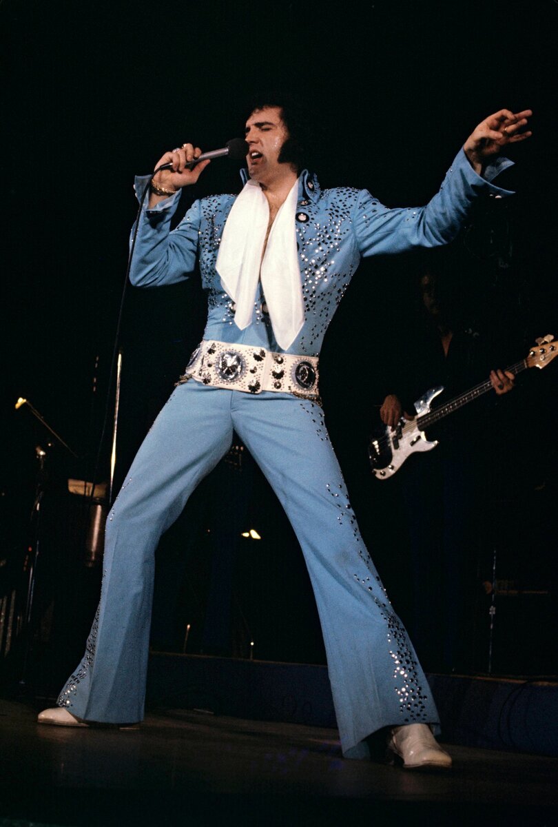 Элвис Пресли выступает в Лас-Вегасе в небесно-голубом комбинезоне, разработанном Биллом Белью. 