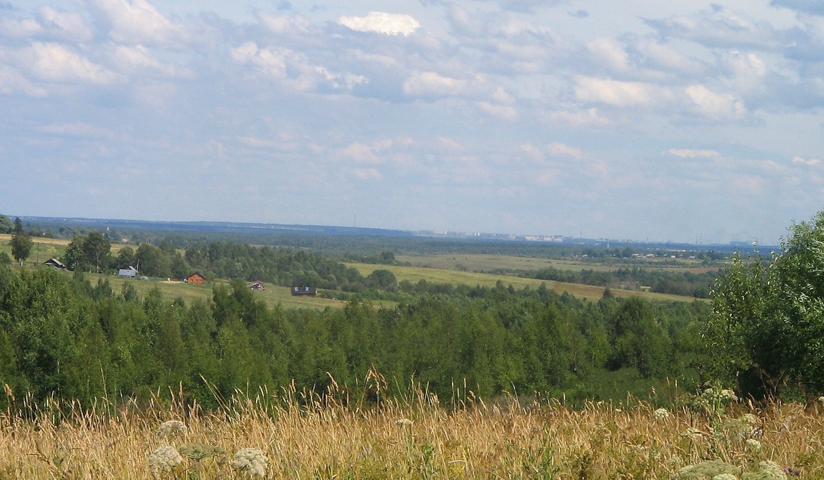 Фото - вид с моей малой родины. На горизонте справа виден город - далеко он. Фотокамера приблизила его - на самом деле днем он не так заметен. Когда темно, видны огни города.