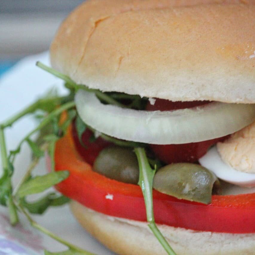 Этот сэндвич - специалитет французской кухни, а именно средиземноморской, придумали его в Ницце. В дословном переводе с французского pan bagnats означает "купающийся хлеб" так как в оригинальном рецепте булочку очень сильно пропитывают соусом. В моем рецепте мы ее просто сбрызнем оливковым маслом, будет не менее вкусно; как правило, в такой сэндвич кладут консервированного тунца или (и) анчоусы, мы же положим консервированные мидии🙂