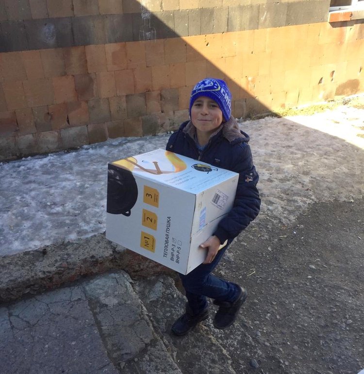 Ученики помогают разгружать доставленные в село обогреватели