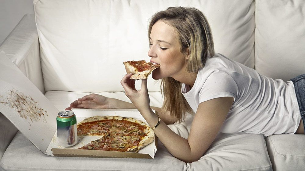 Съесть совсем. Лежит на диване с едой. Человек ест. Человек на диване с едой. Девушка кушает.