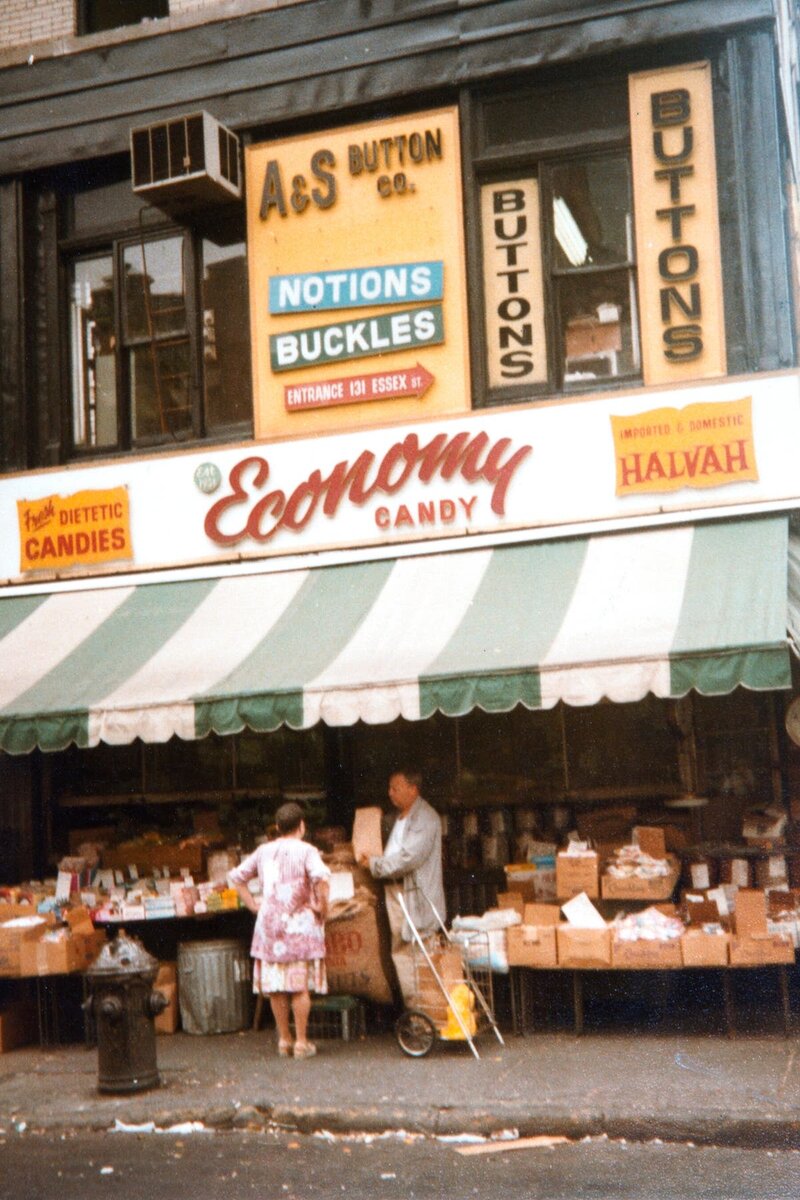 Моррис «Мойше» Коэн помогает покупателю возле Economy Candy, 1960-е годы. Говорят, что он стоял снаружи в любую погоду, чтобы обслуживать клиентов