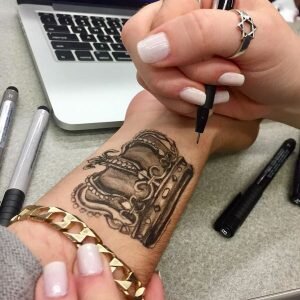 Завершив нанесение тату на кожу, ее следует покрыть тальком, аккуратно втирая его в изображение. Если необходимо избавиться от размытых контуров и излишнего талька, то рекомендуется использовать ватный диск или палочку. Выполнив вышеуказанные шаги, остается применить лак для волос, предназначенный для средней или сильной фиксации. Это средство позволяет продлить срок существования временной татуировки до 1-2 месяцев.
